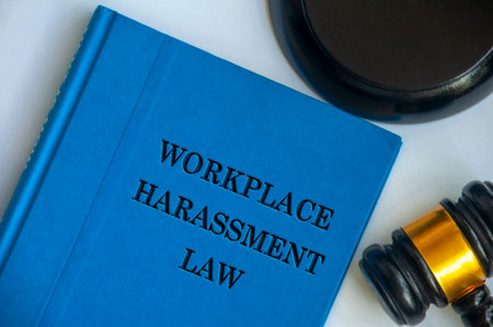 Top view of Workplace Harassment Policy blue book with gavel on white background. Zero workplace harassment concept.の写真素材