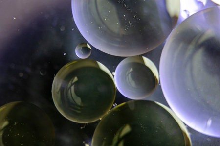 Extreme close up of oil bubbles on water surface.の写真素材