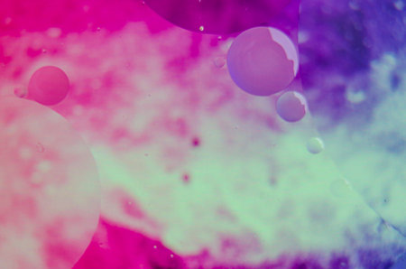 Macro shot of oil droplets forming clusters, set against a gentle gradient.