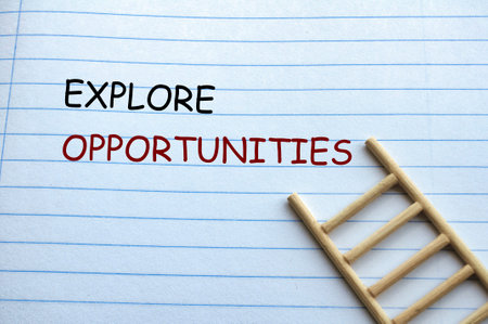 Explore Opportunities text on notebook with wooden ladder background.