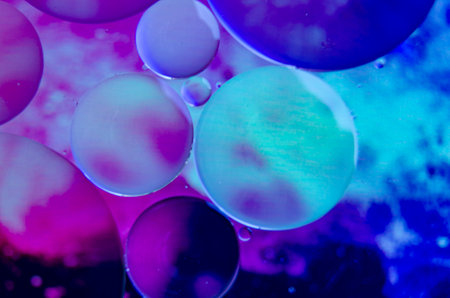 Macro shot of oil droplets forming clusters with multicolored blue gradient.の写真素材