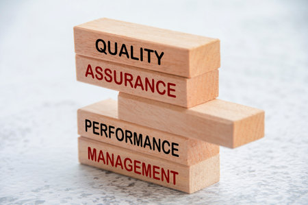 Quality Assurance and Performance Management text on wooden blocks. Business and quality assurance concept.の写真素材