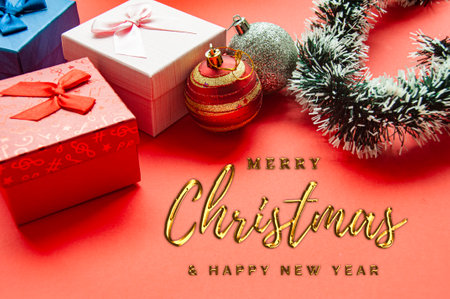 Golden Merry Christmas and Happy New Year Wishes text with Christmas ball and present background....
