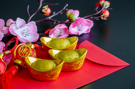 Golden Ingots on top of Chinese New Year red packet. Chinese New Year celebration.の写真素材
