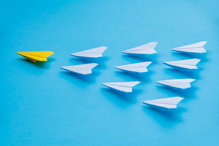 Leadership concept, yellow paper airplane origami leading other white airplanes. Leadership skills concept.の写真素材