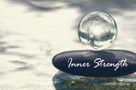 Inner Strength text on zen stone with bright shining glass marble. Inner strength concept.の写真素材