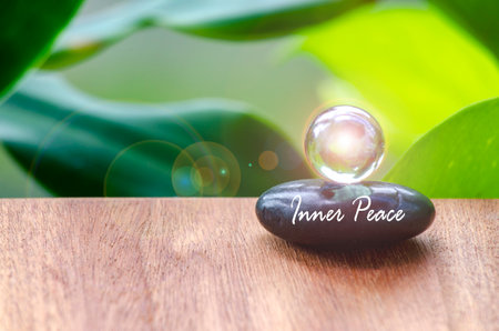 Inner peace text on zen stone with bright shining glass marble. Inner strength concept.の写真素材