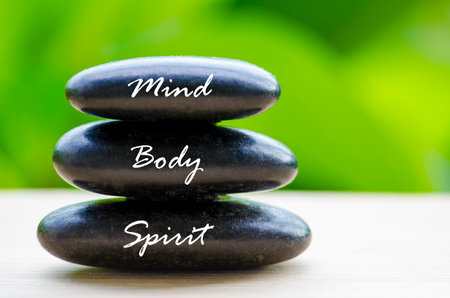 Close up of black Zen stones with Mind Body and Spirit text on the stones. Zen and peaceful concept.の写真素材