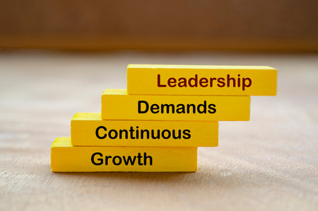 Leadership Demands Continuous Growth text on yellow wooden block. Leadership concept.の写真素材