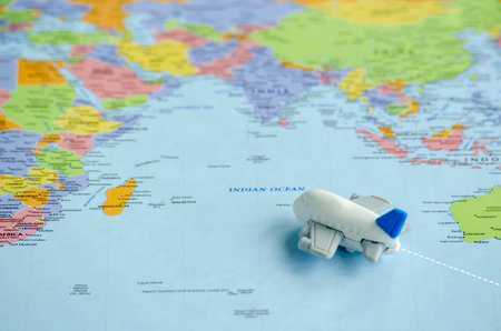 Small airplane placed on a world map heading to its destination.の写真素材