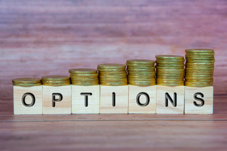 Options text on wooden cubes with stacking golden coins. Business concept.の写真素材