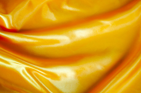 Top view of yellow silk cloth with silky sheen suitable for design and wallpaper backgroundの写真素材