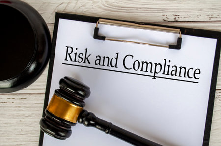 Top view of Risk and Compliance text on clipboard with gavel on top. Code of Conduct conceptの写真素材