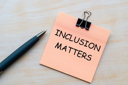 Inclusion matters text on pink notepad representing the importance of diversity and belonging in all...