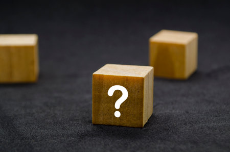 Three wooden cubes with question marks aligned in a row.の写真素材