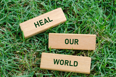 Heal Our World text on wooden blocks, symbolizing a hopeful message to restore environmental...