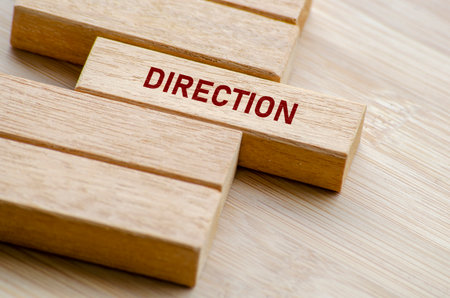 Direction word shown on separated wooden blocks on a table, representing focus, vision, and the ability to guide others with purpose and clarityの写真素材