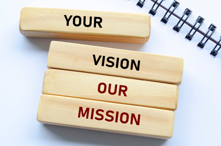 Your vision our mission text on wooden blocks and notebook emphasizes alignment with client goals and shared purposeの写真素材