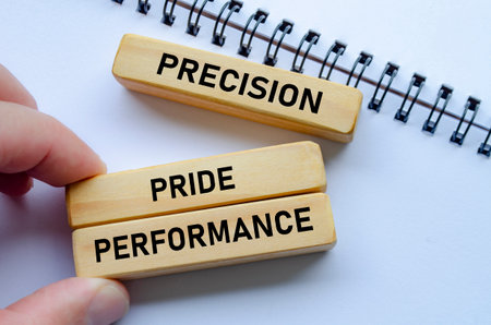 Precision through performance shown on wooden blocks over a notepad signifies the importance of accuracy in achieving successの写真素材