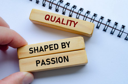 Quality shaped by passion text on wooden blocks over a notepad reflects teamwork driven by genuine enthusiasmの写真素材