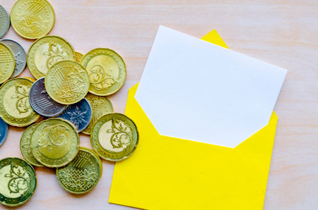 Coins and white notepad in an envelope with customizable space for text or ideas.