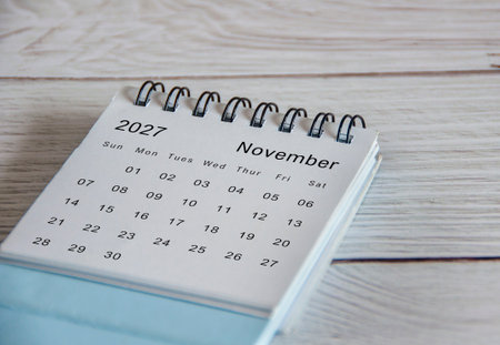 Close up of November 2027 calendar on wooden background.