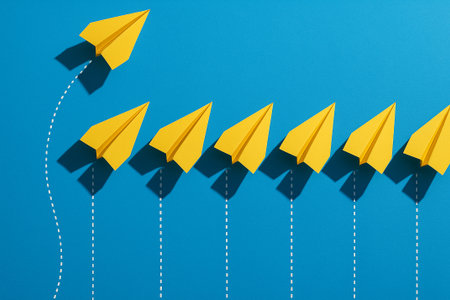 Four yellow airplanes in front leading blue airplanes in a square arrangement representing structured leadership.の素材