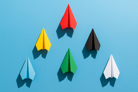 A yellow airplane rising higher than blue and white airplanes to symbolize aspirational leadership.の素材