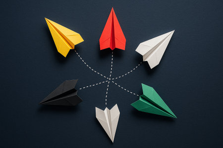 A red paper airplane standing out while leading white airplanes against a dark background for leadership through difference.の素材