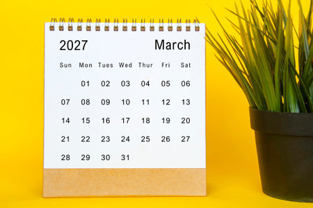 March 2027 calendar design template with neat white background, bold yellow accent, and plant besideの写真素材
