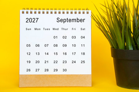September 2027 simple monthly desk calendar layout with vibrant yellow edge and green plant accessoryの写真素材