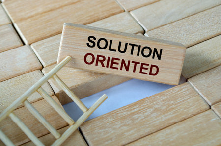 Solution oriented text written on wooden blocks set on a ladder symbolizing problem-solving...