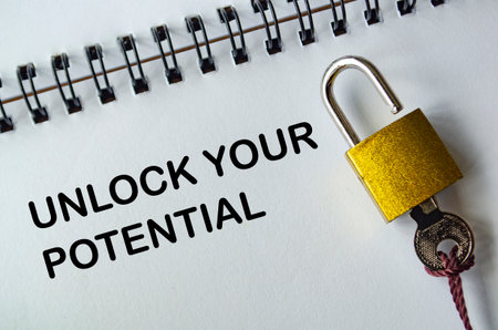 UNLOCK YOUR POTENTIAL, Motivational notepad with padlock and key representing growth and capabilitiesの写真素材