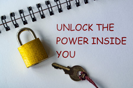 UNLOCK THE POWER INSIDE YOUR JOURNEY, Motivational notepad with padlock and key emphasizing discoveryの写真素材
