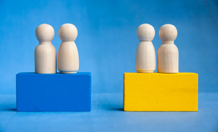 Wooden figures grouped on blue and yellow blocks symbolize social division, leadership hierarchy,...