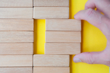 Top view of hand pulling wooden blocks with customizable space for teamの写真素材
