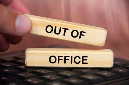 Hand placing out of office text on wooden blocks. Getaway or on a vacation conceptの写真素材