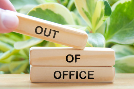Out of office text on wooden blocks with nature background. Getaway or on a vacation conceptの写真素材