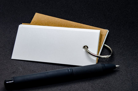 White banner shape notepad with customizable space for text on black cover background and black penの写真素材