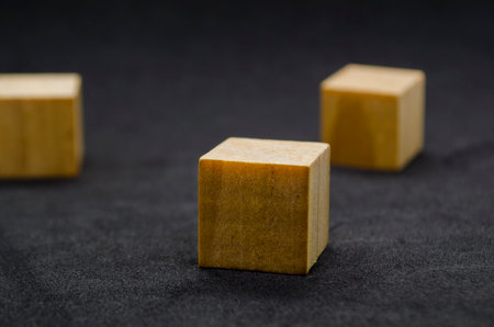 Isolated wooden cubes on dark background with customizable space for text or ideasの写真素材