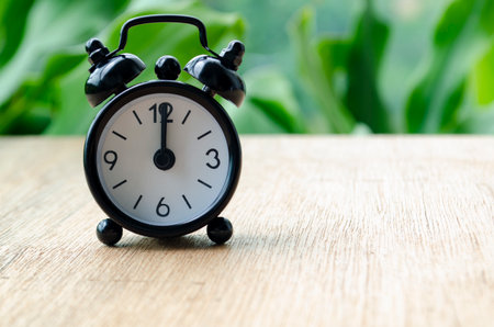 Alarm clock pointing at 12pm with customizable background space for text or ideas. Time concept