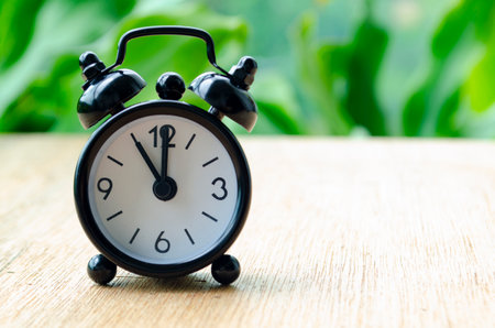Alarm clock pointing at 11 am with customizable background space for text or ideasの写真素材