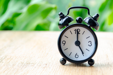 Alarm clock pointing at 5 pm with customizable background space for text or ideas. Time conceptの写真素材