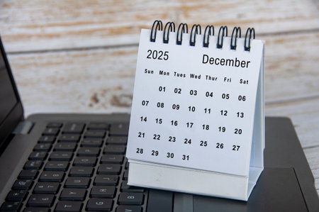 White calendar of December 2025 calendar on top of laptop. Year end concept.の写真素材