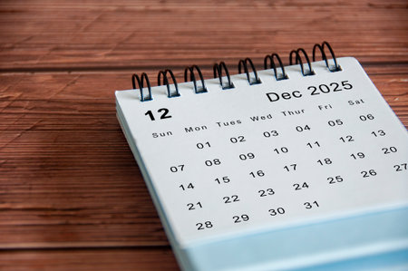 Side view of December 2025 calendar on wooden table. Year end concept.の写真素材