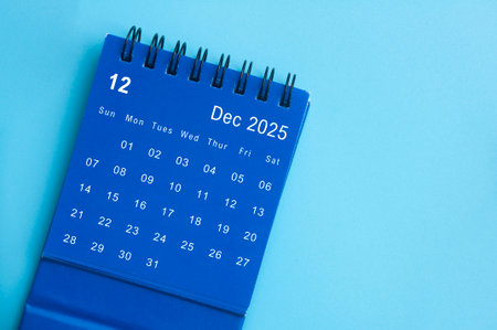 Top view of blue December 2025 desk calendar on blue cover background. December month and year end concept.の写真素材