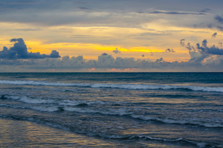 Golden hour ocean scene with warm sky, textured waves, and a bright band of sunlight, Kuala Penyu, Sabah, Malaysiaの写真素材
