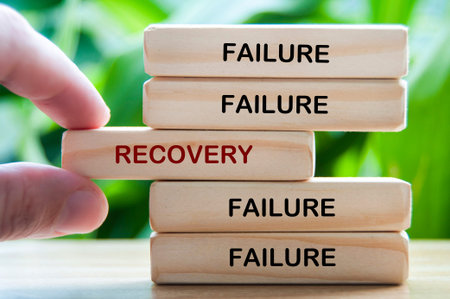 Failure and Recovery text on wooden blocks representing bouncing back from failure through learning and resilienceの写真素材