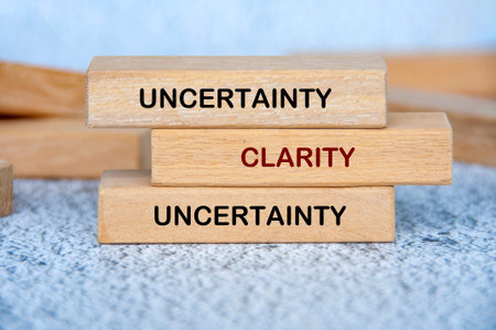 Uncertainty and Clarity text on wooden blocks representing finding clarity and direction in uncertain situationsの写真素材