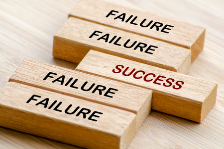 Failure and Success text on wooden blocks representing turning setbacks into success through persistence and strategyの写真素材